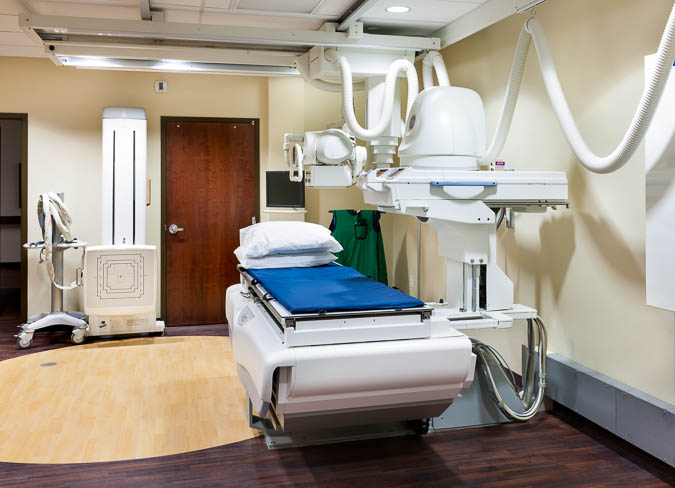 Picture of a room with an X-ray machine and Radiology equipment. 
Routine radiography procedures are done on the order of a physician. The studies performed vary and cover most body areas. The procedures for taking general radiographs vary depending upon the length of time required to image different anatomy
