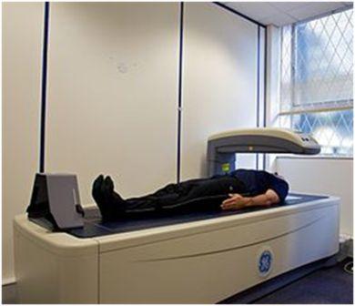 Picture of a Bone Density Scan Machine with a man lying down flat