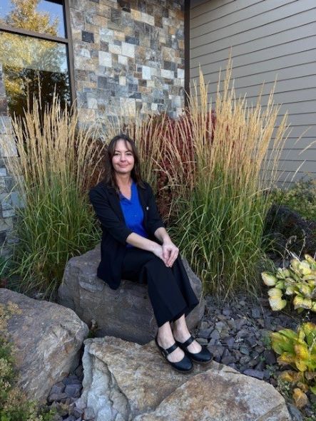 Autumn Diller sitting outside on a rock